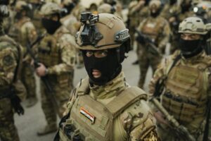 Group of soldiers in tactical gear with helmets and masks, ready for action.